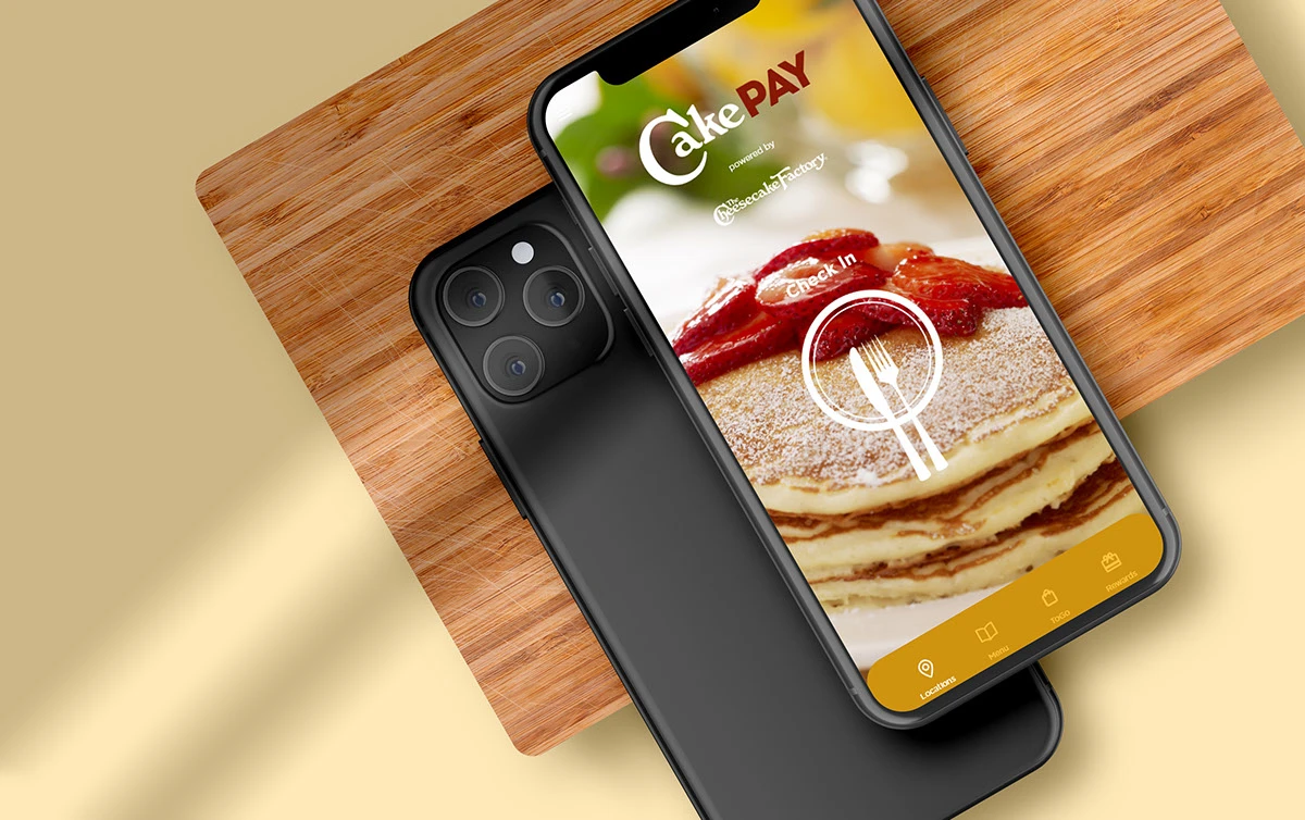 CakePay check-in screen on a phone over a cutting board